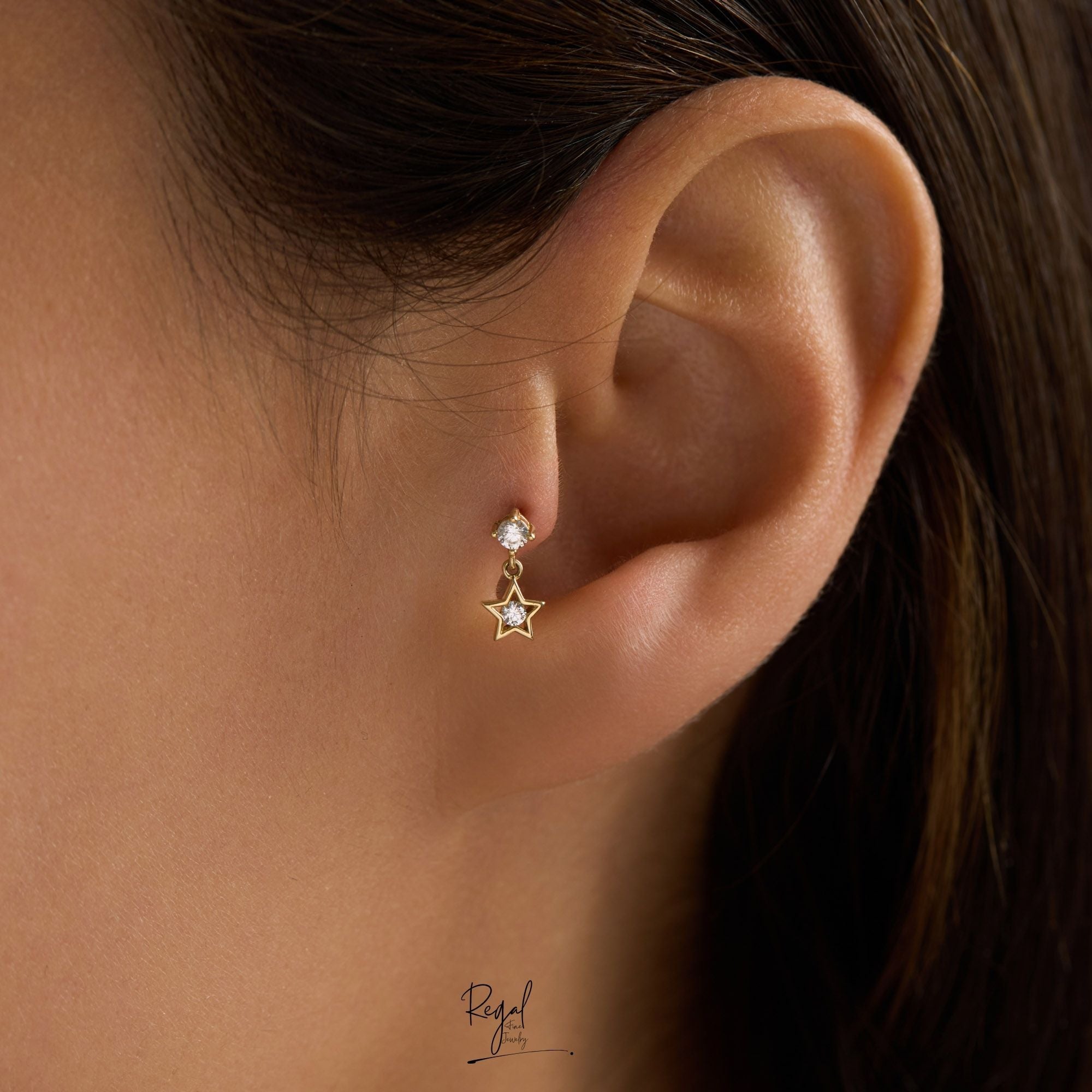 Close-up of an ear wearing a star-shaped piercing on tragus