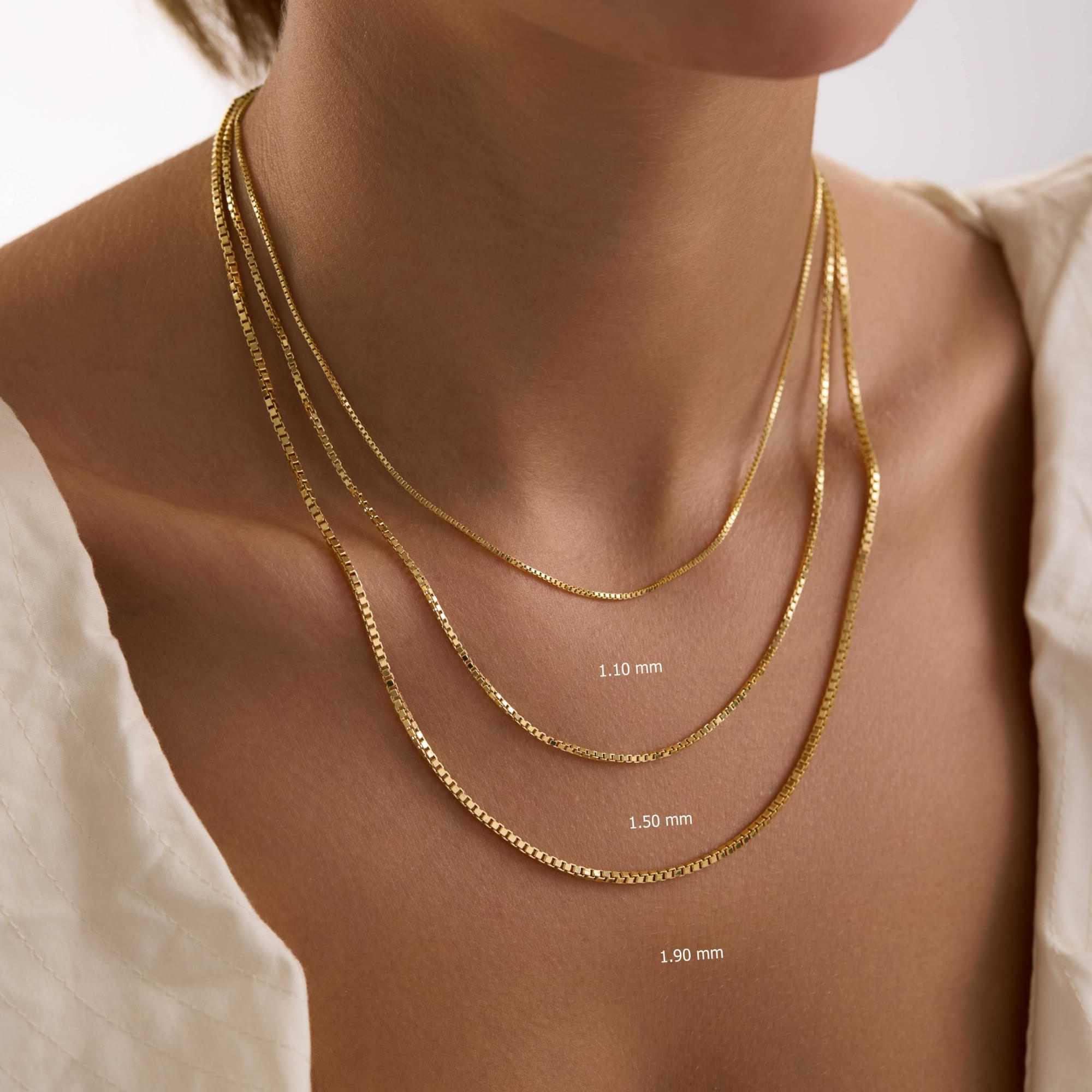 Three 14k gold box chain necklaces of different thicknesses on a person's neck with measurements indicated.