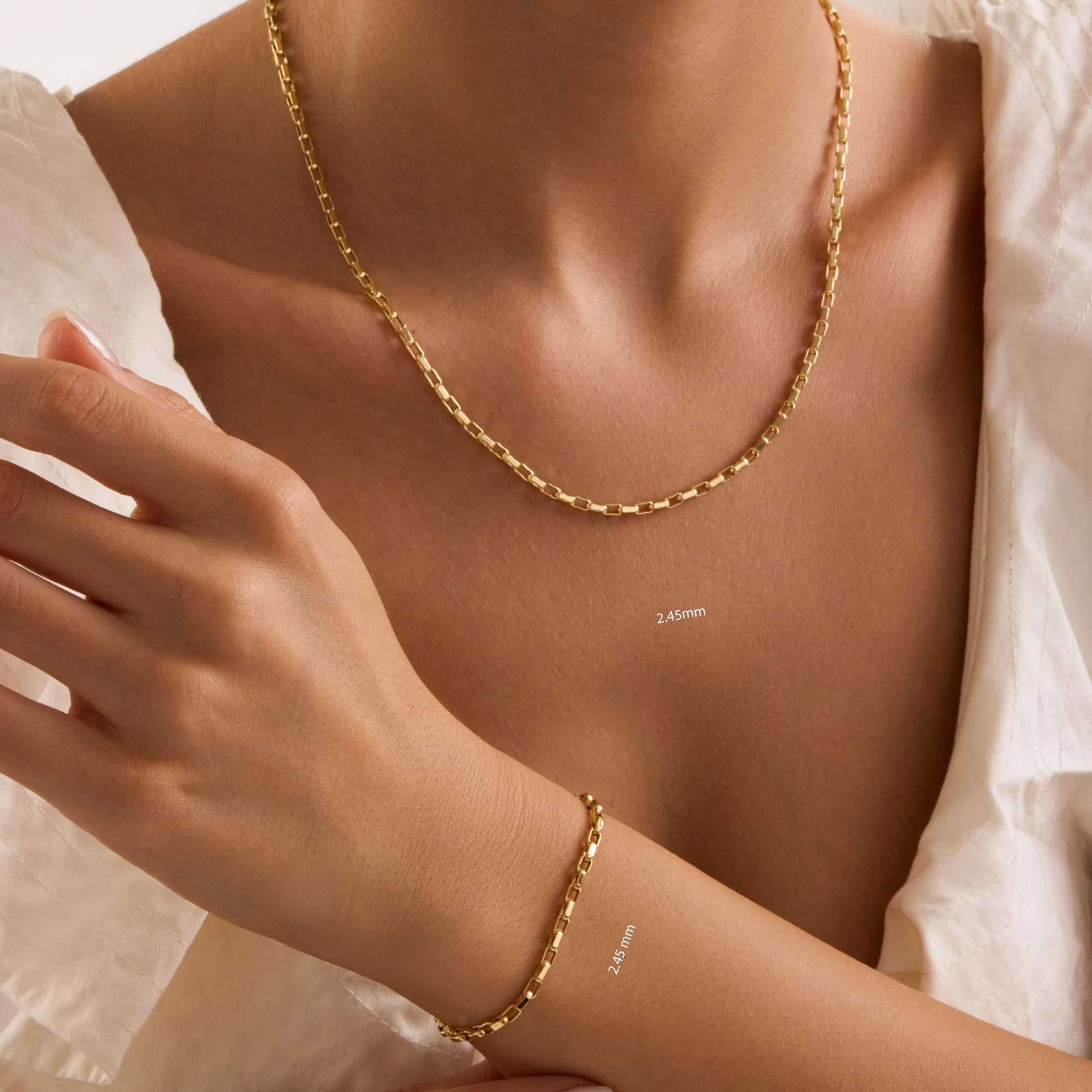 Gold 2.45mm cable chain necklace and bracelet on a person with a neutral background