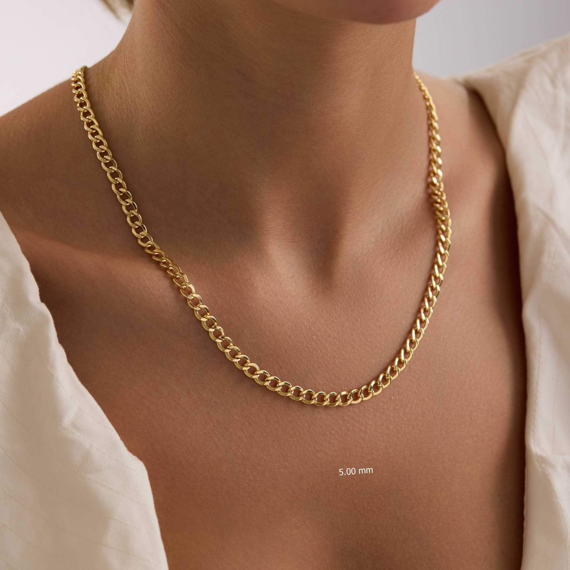 Gold 5mm curb chain necklace on a person with a plain background