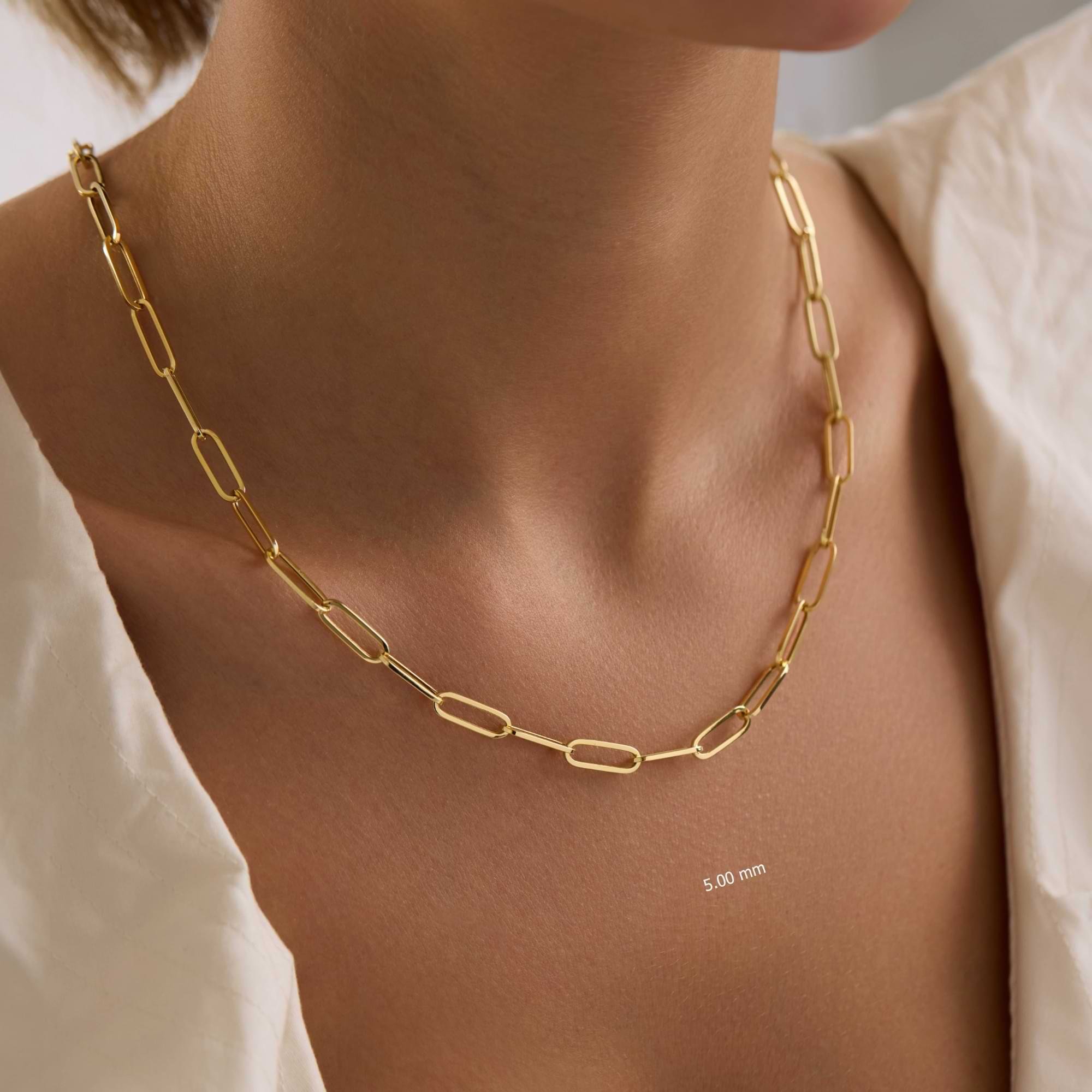 Gold 5mm paperclip chain necklace on a person with a neutral background