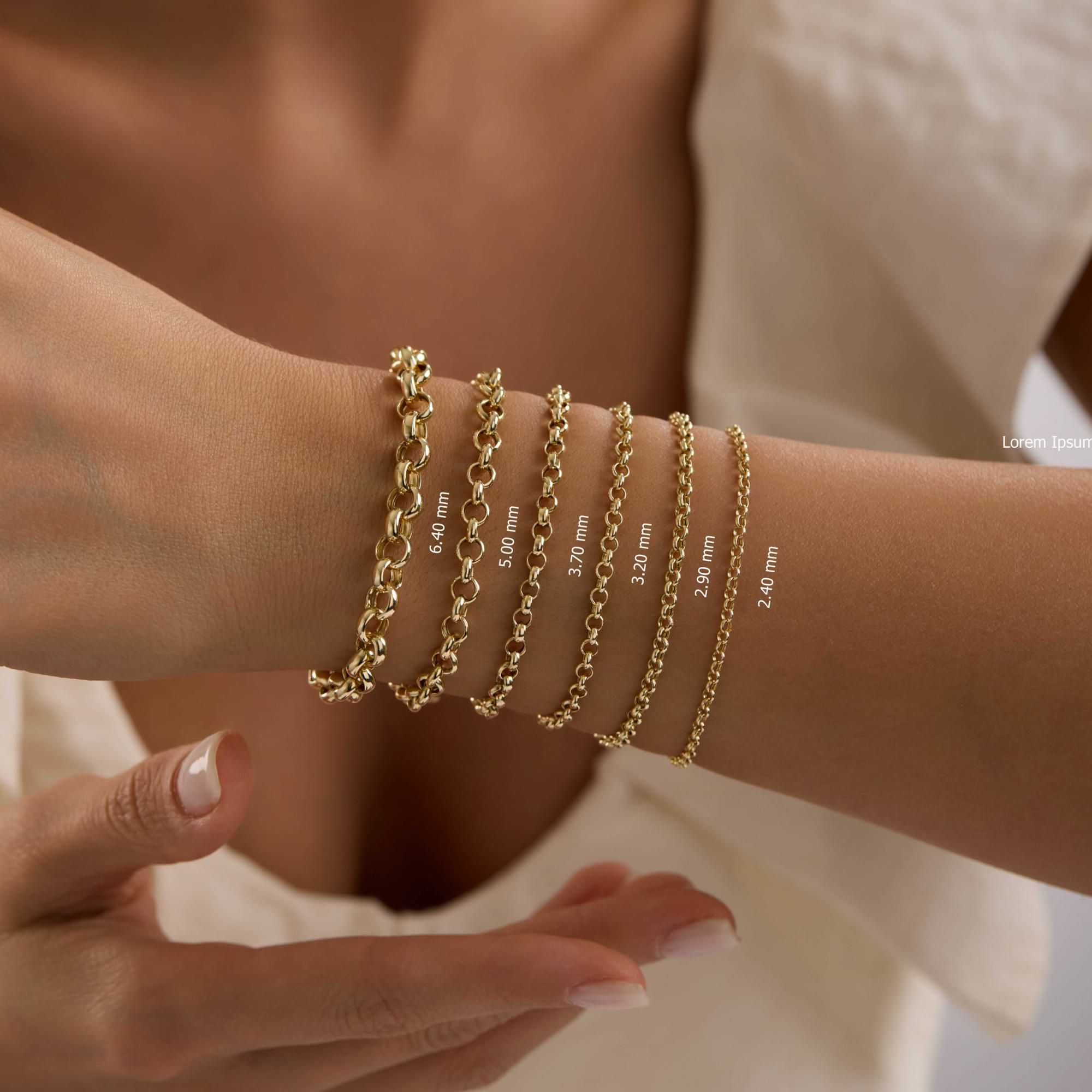 14k Gold rolo chain bracelets of different thicknesses on a wrist of woman wearing white dress