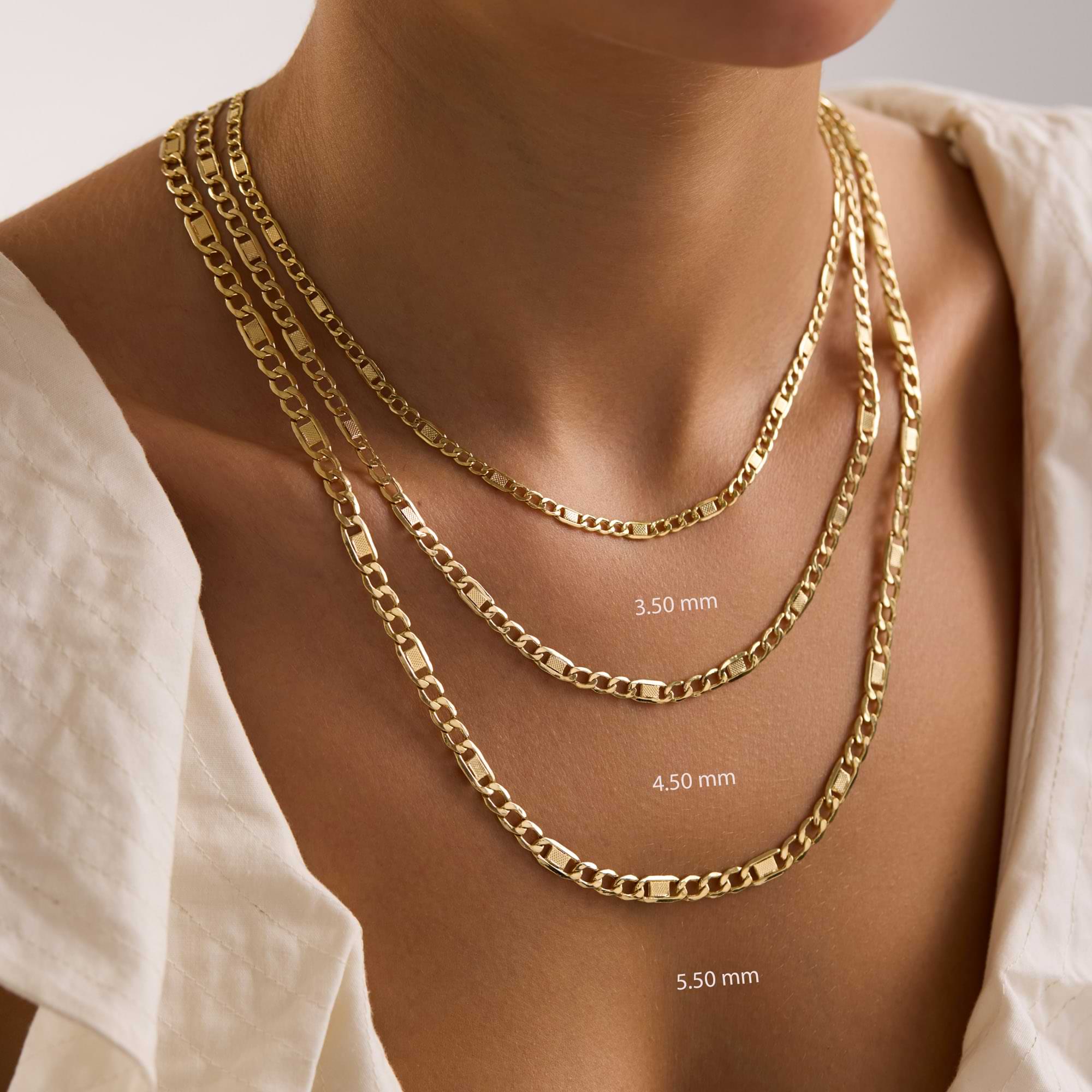 14k Gold figaro chain necklaces of different thicknesses on a woman's neck with measurements.