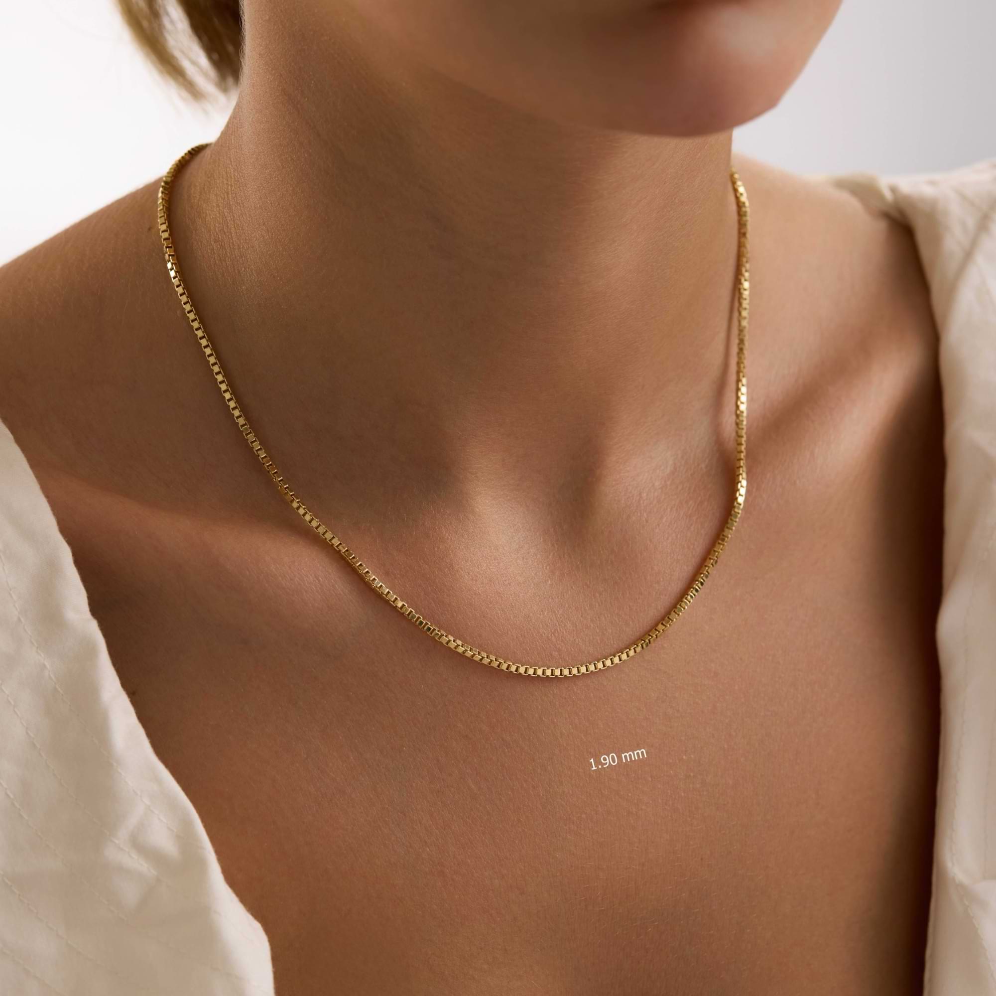 Gold 1.1mm box chain necklace on a woman