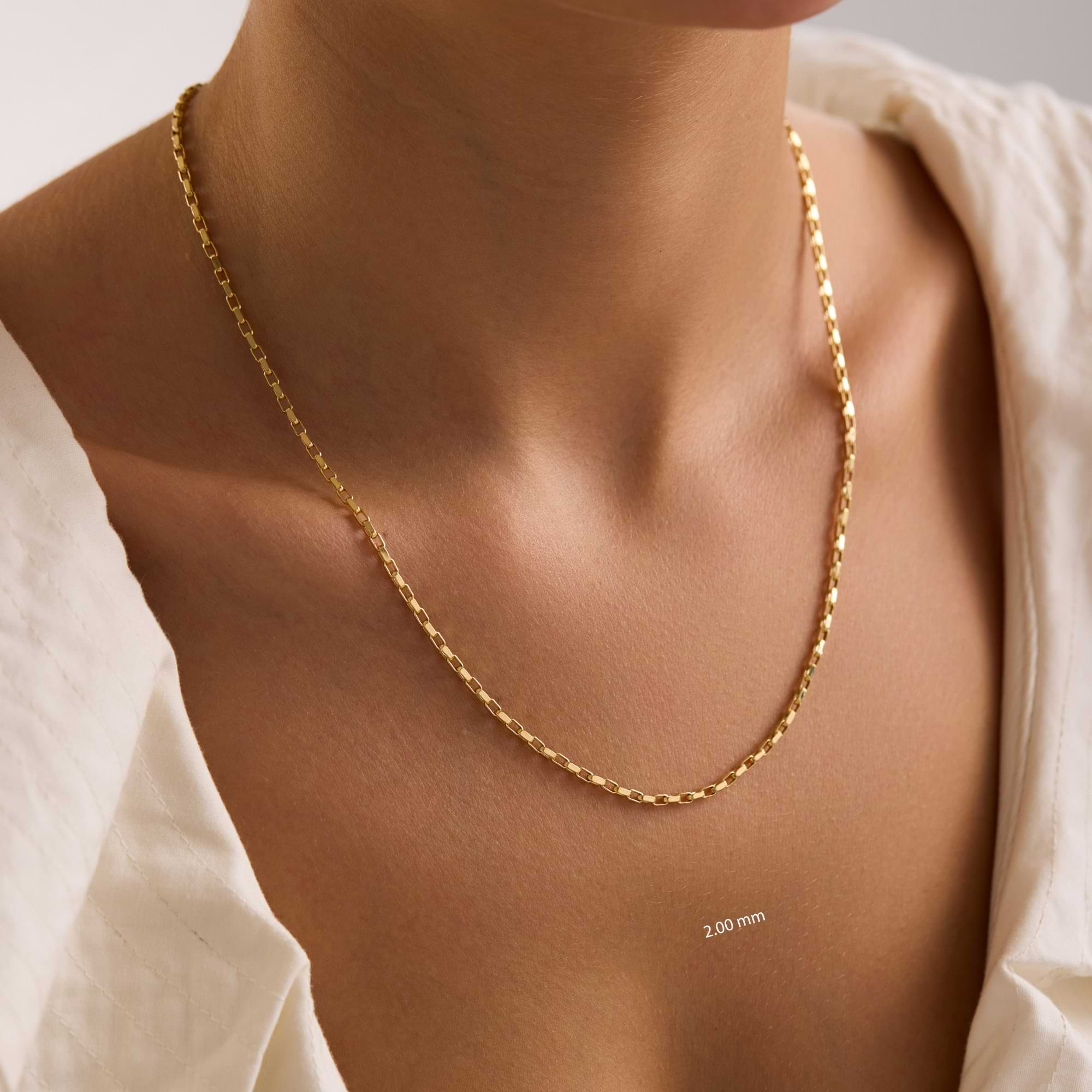 14k Gold 2mm cable chain necklace on a woman with a neutral background