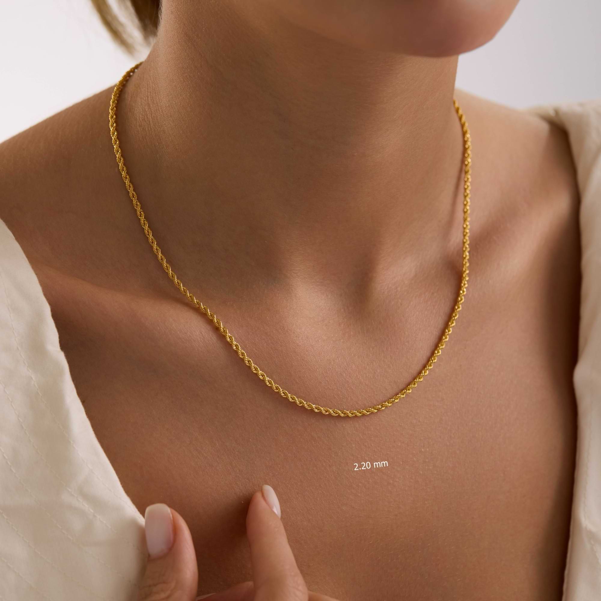Gold 2.2mm rope chain necklace on woman's neck.