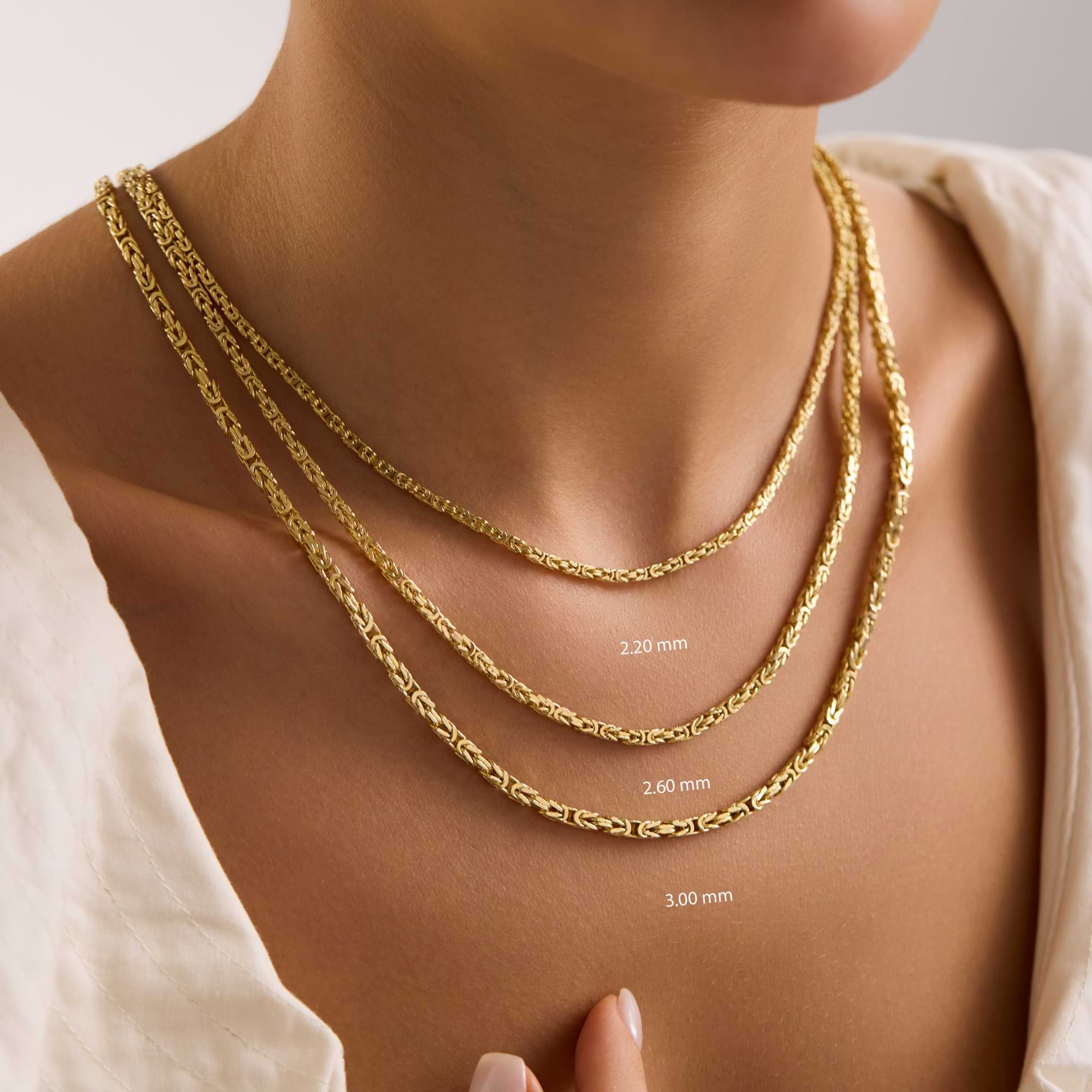Three gold byzantine chains of different thicknesses 2.2mm 2.6mm 3mm on a womans neck 