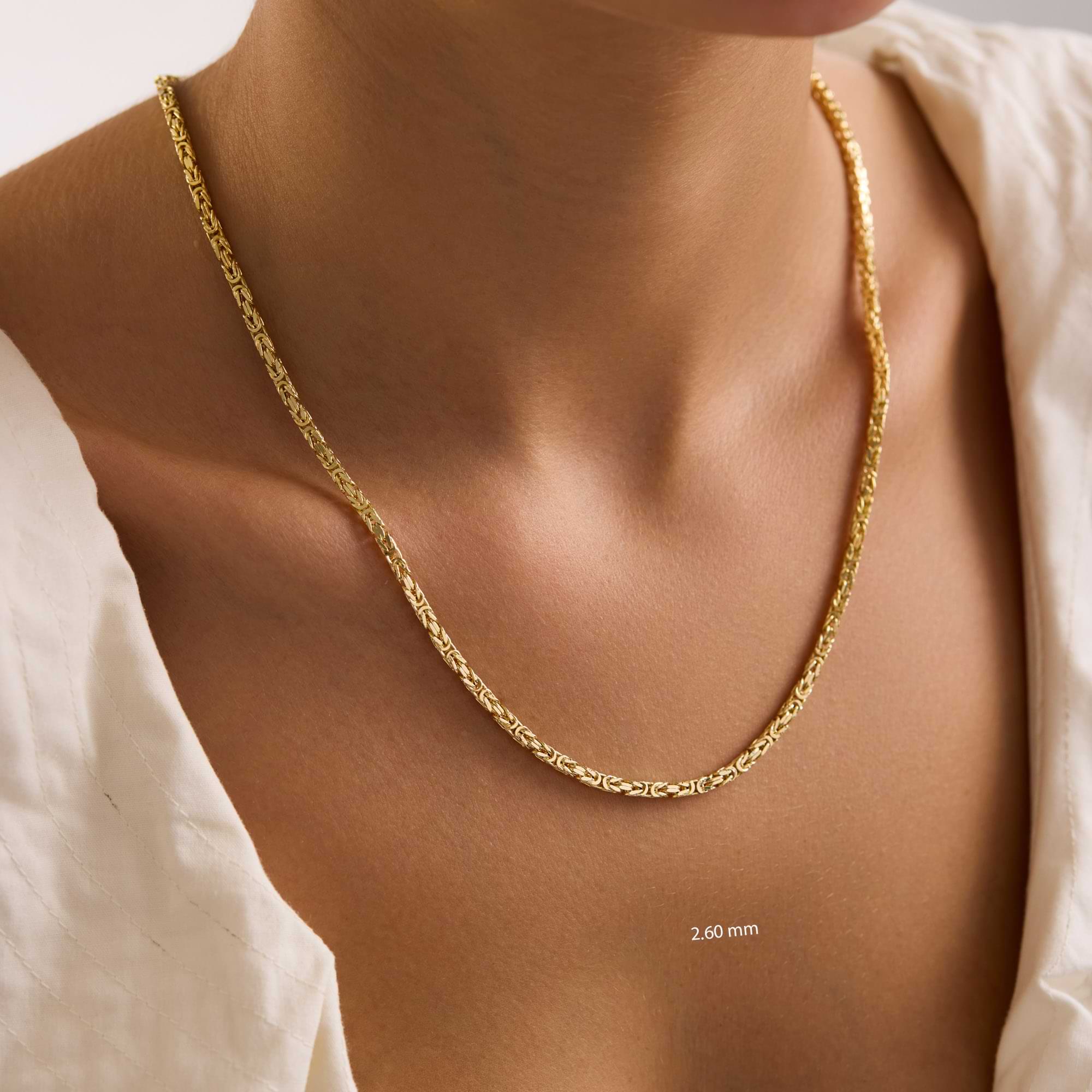 14k Gold 2.6mm byzantine chain necklace on a person with a plain background