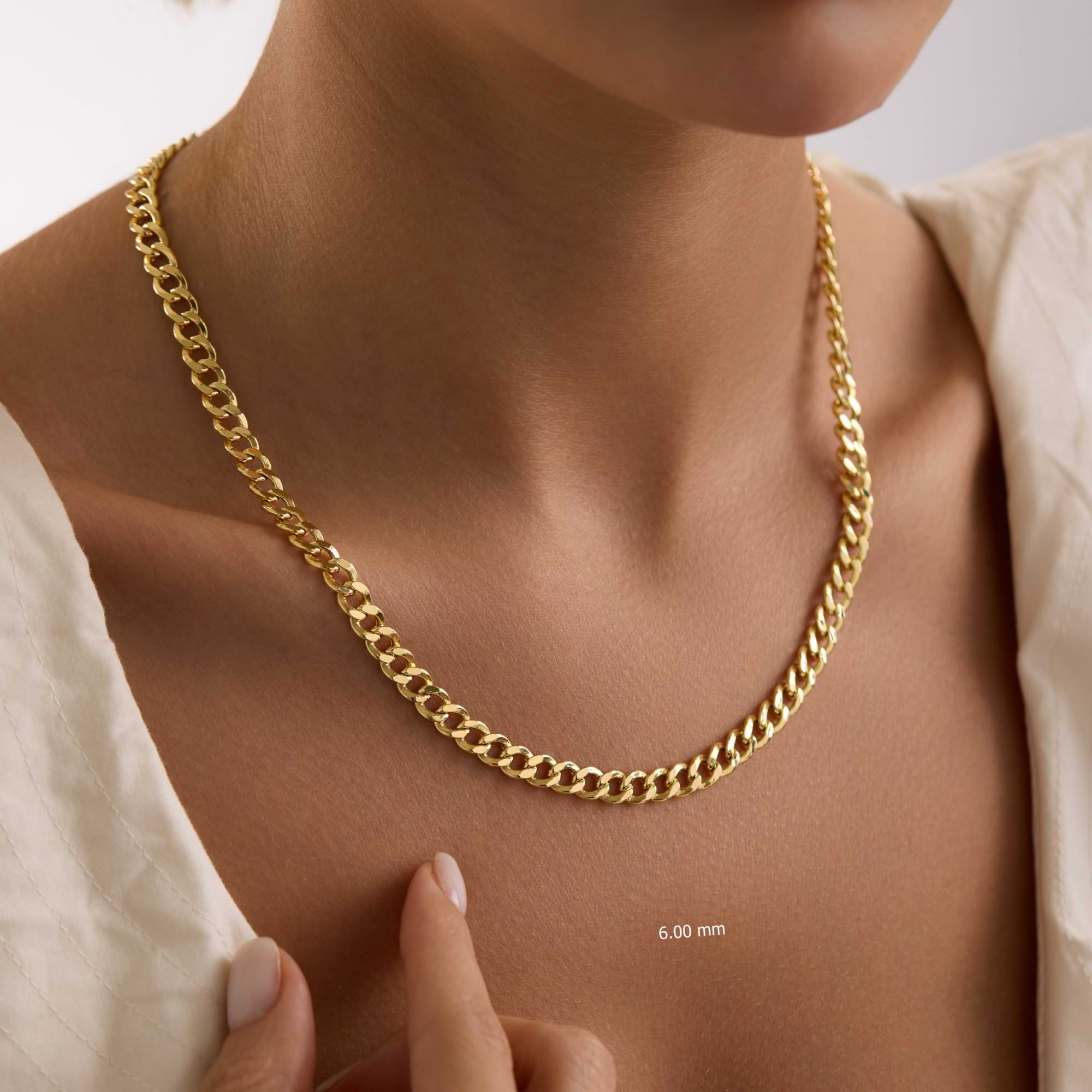 Gold 6mm curb chain necklace being worn on a person's neck with a close-up of the chain width.