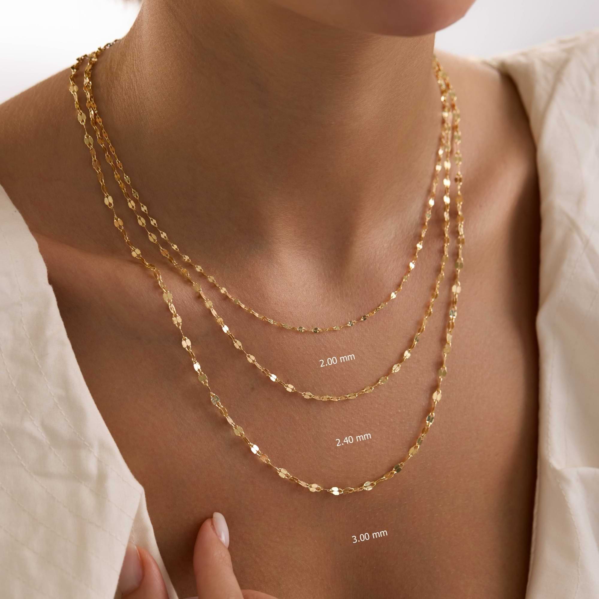 Gold sequin necklaces of different thicknesses on a person's neck with measurements.