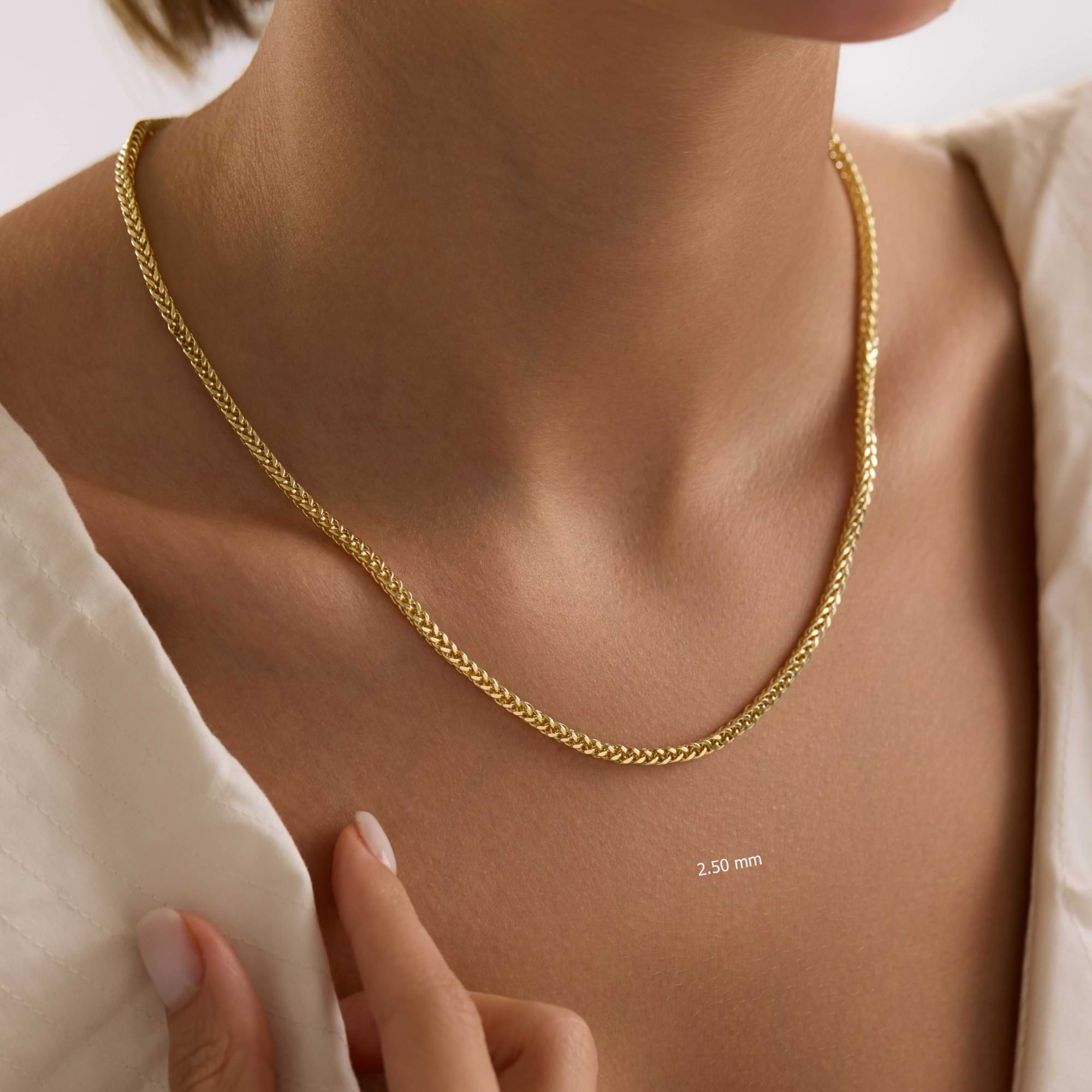 14K Gold 2.5 mm Spiga chain necklace on a lady with a plain background