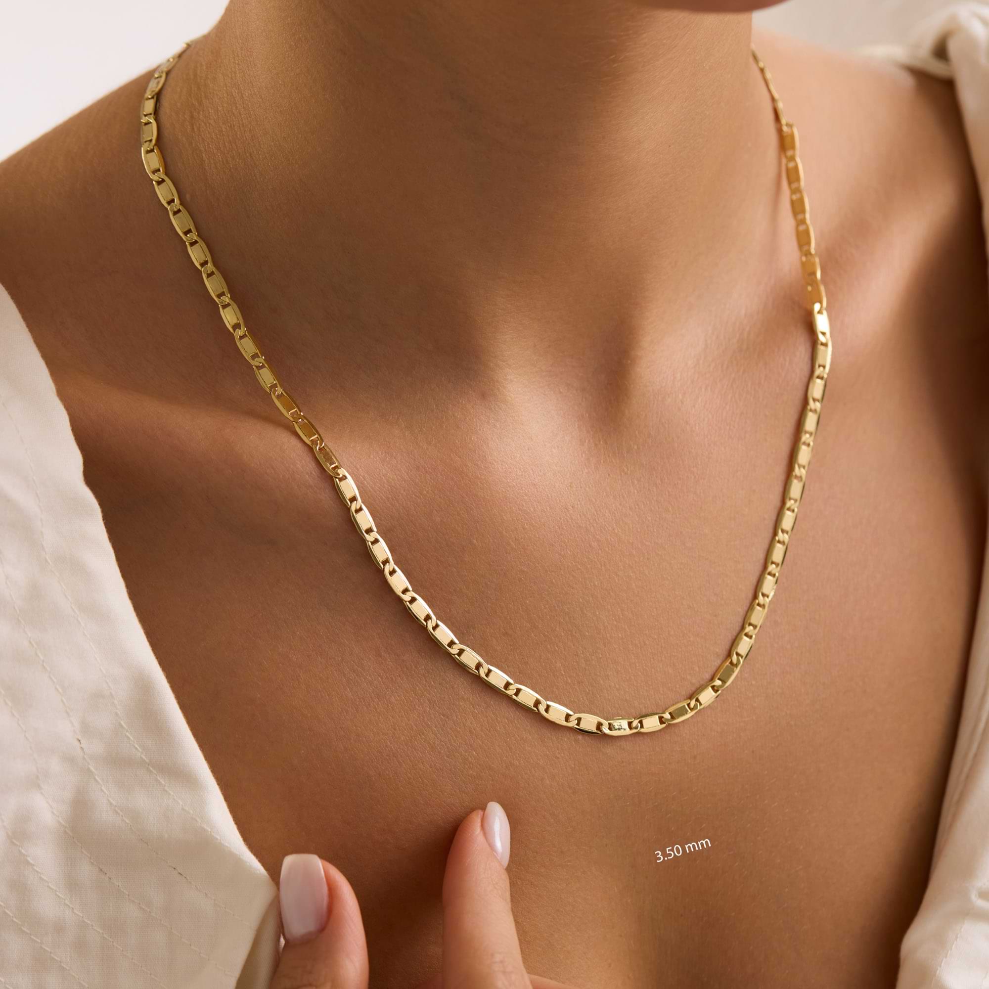 Gold 3.5mm valentino chain necklace being worn on a woman's neck with a neutral background