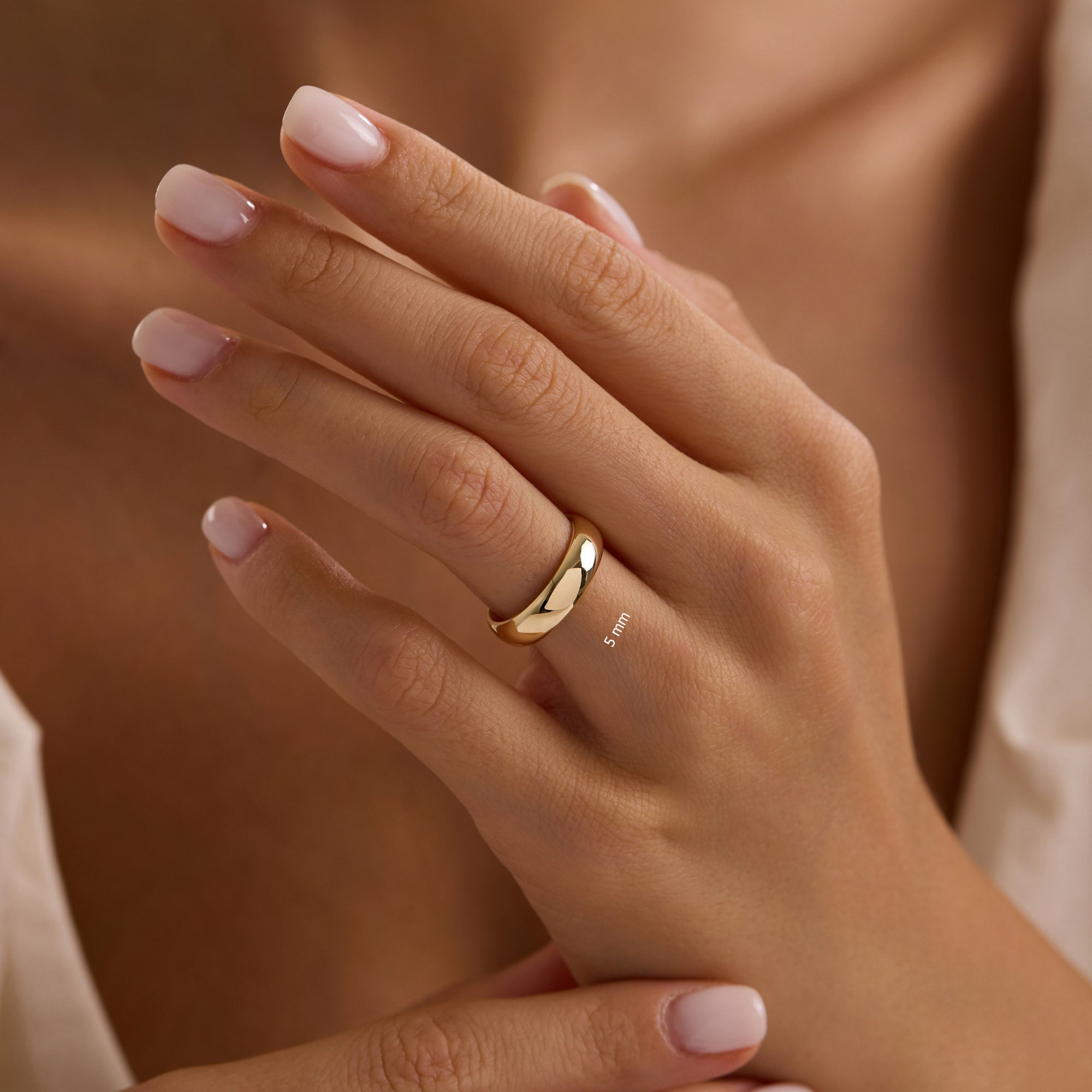 Close-up of hand wearing 5mm 14k yellow gold wedding band.