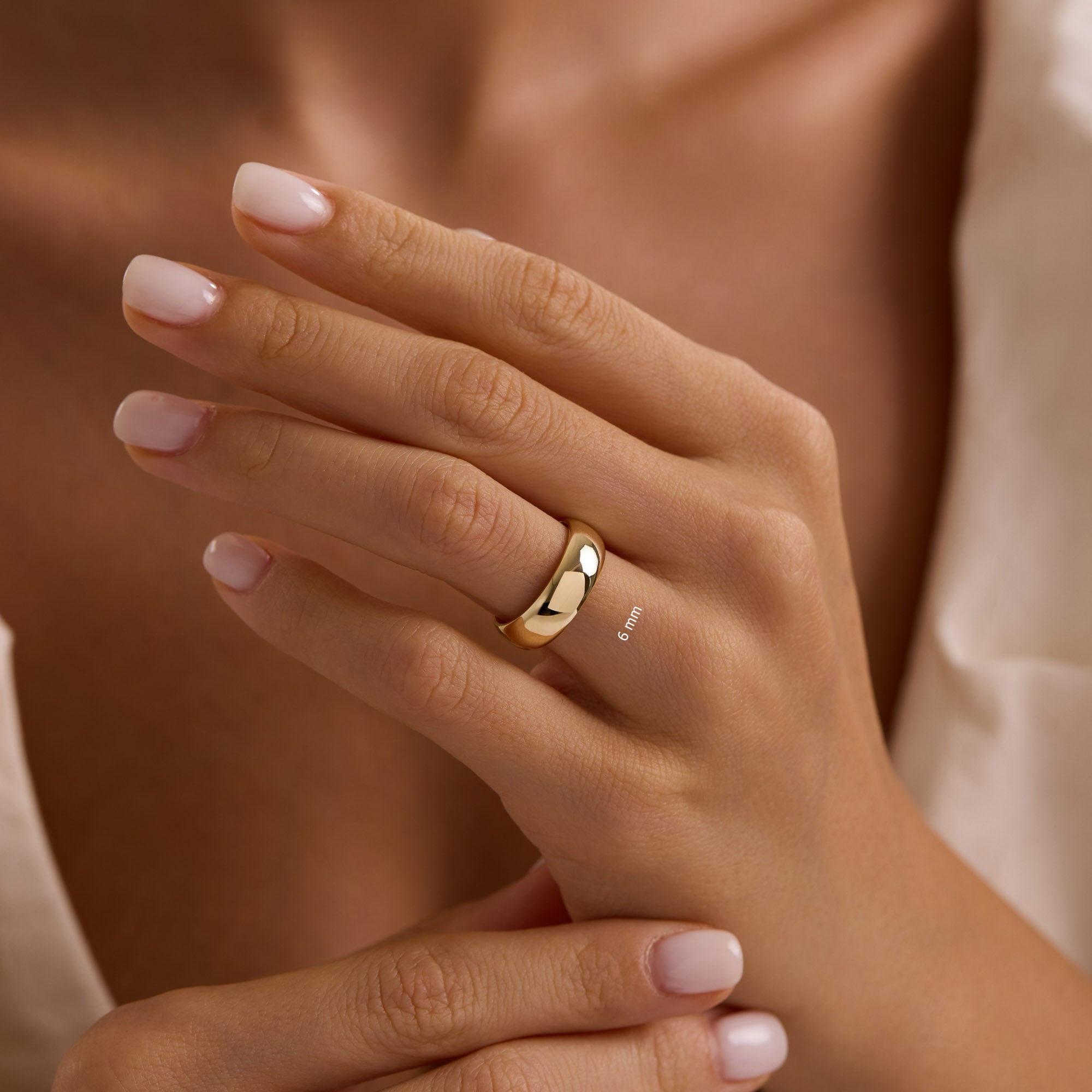 14k solid yellow gold 6mm wedding band on woman’s hand, bold polished dome ring.