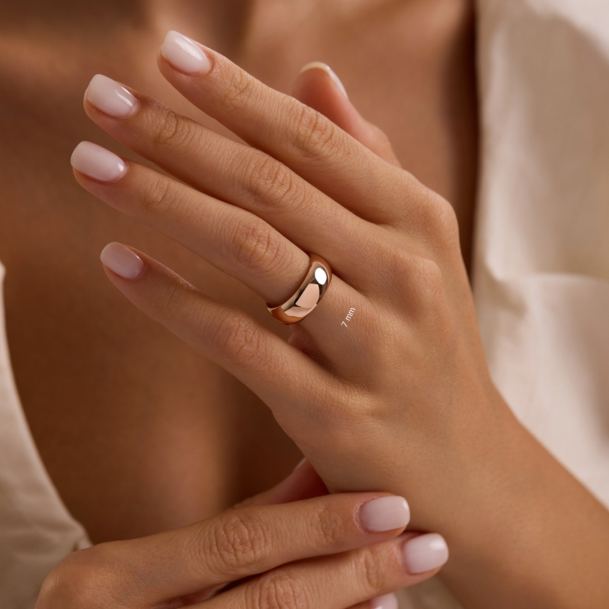 Close-up of hand wearing 7mm 14k rose gold wedding band.