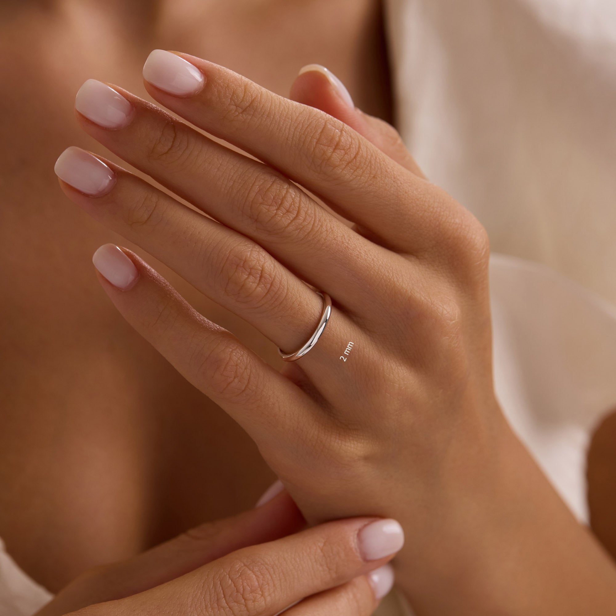 Close-up of hand wearing 14k solid white gold 2mm classic dome band.