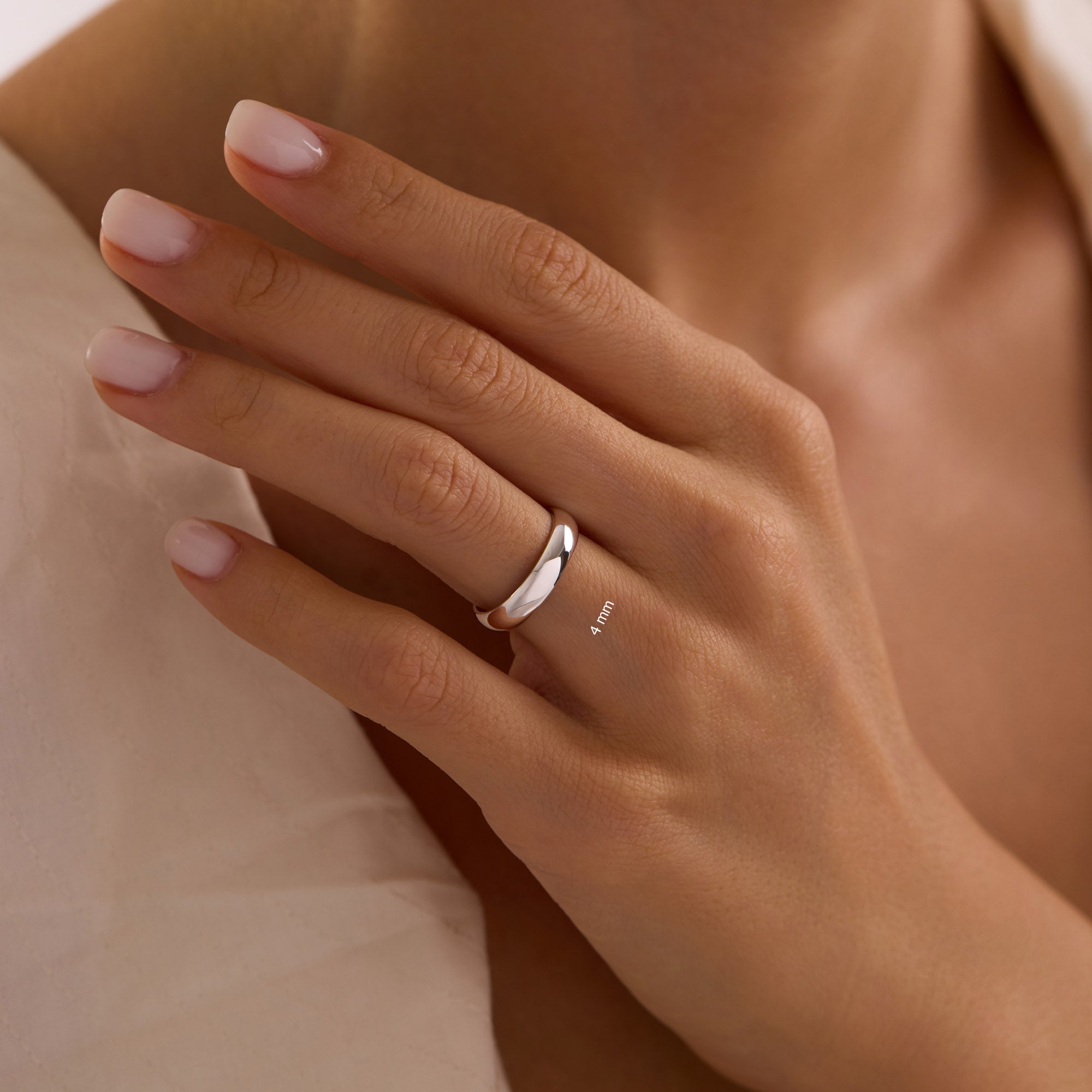 Close-up of hand wearing 4mm 14k white gold dome wedding band