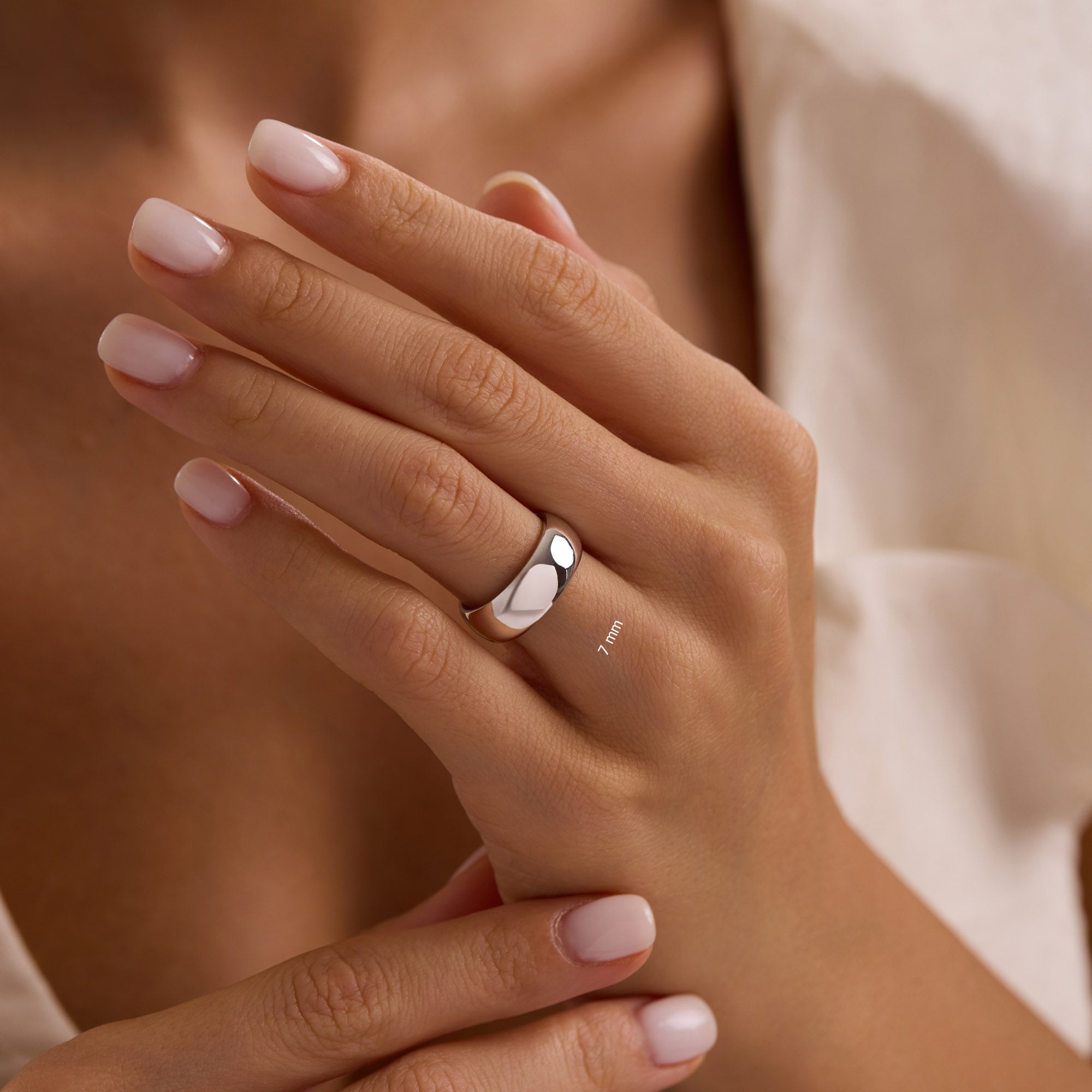Close-up of hand wearing 7mm 14k white gold wedding band.